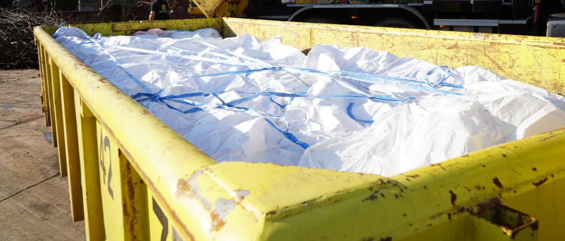 asbest container met asbest afgedekt met bache