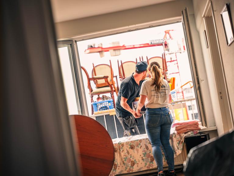 twee werknemers van GG Recup ruimen woning op