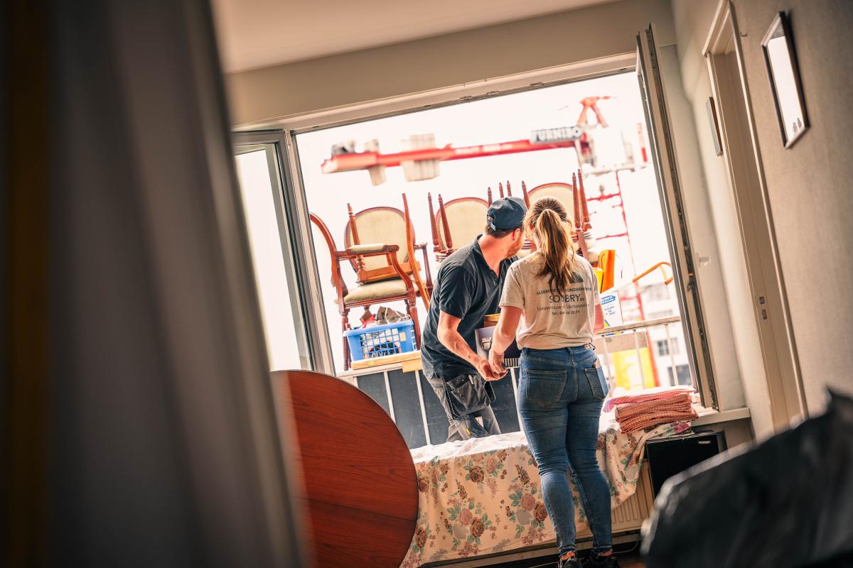 twee werknemers van GG Recup ruimen woning op